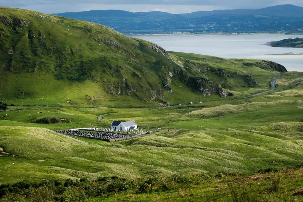 A view of green fields and sand dune with St. Mary's Church in Lagg in the middle distance