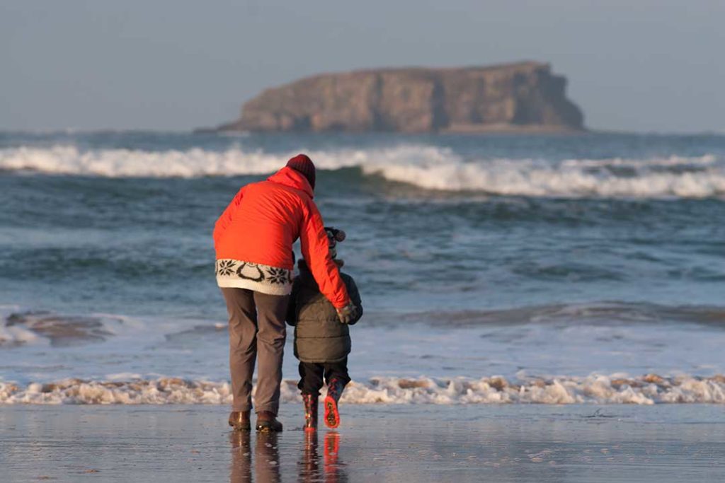 People on Ballyliffin Beach with Sheep Island in the background